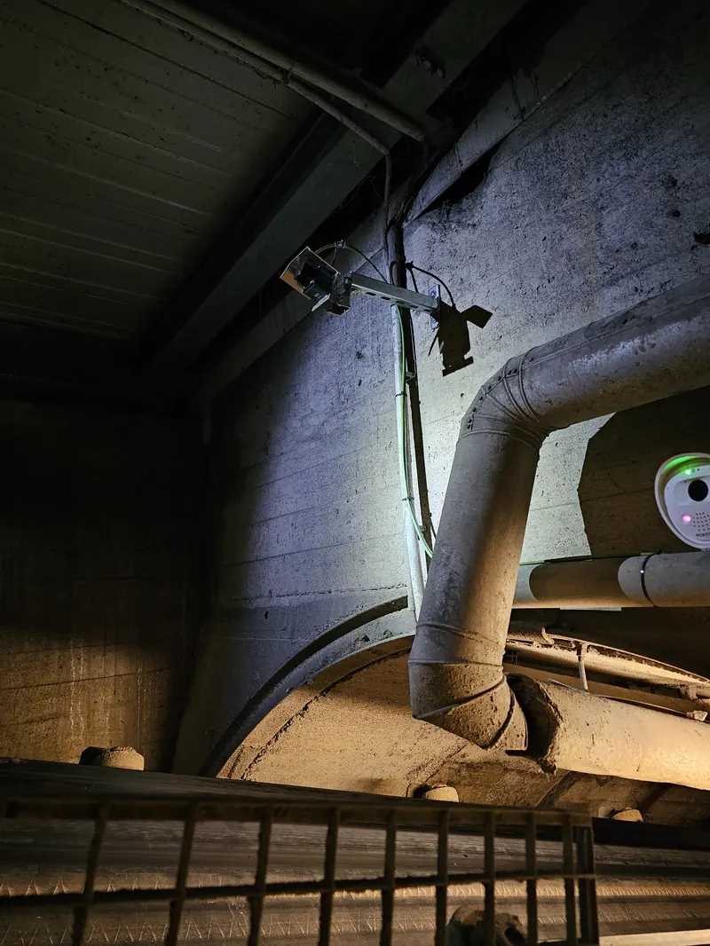 OWL EYE® VOLUME FLOW SICK 2D-LiDAR mounted above a conveyor belt inside a quarry — continuous mass-flow measurement